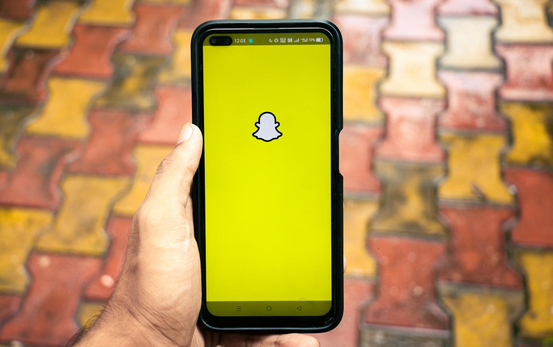 man holding a iphone x with social network service snapchat on the screen iphone x was created and developed by the apple inc snapchat application on iphone x